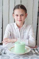 A roll of toilet paper lies on a plate. Girl wants to eat it with a knife and fork.