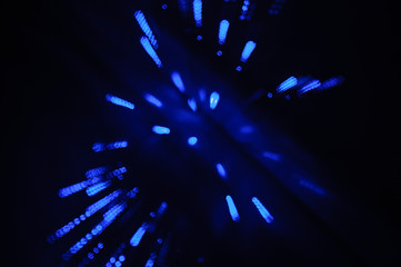 Fototapeta na wymiar Movement of light. Concept of speed. Blue stars or dots. Dark background.