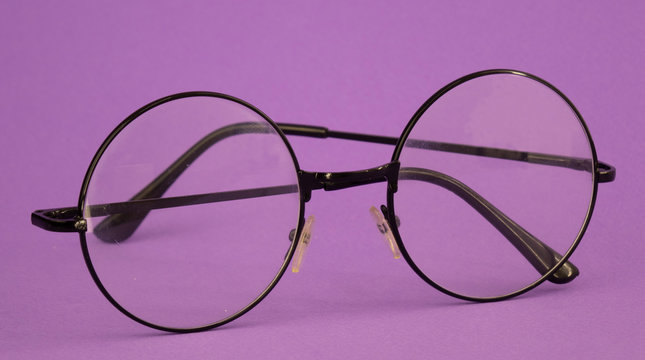 round glasses for vision on a purple background