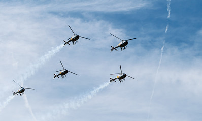 Formation of five military helicopters flies over the ground