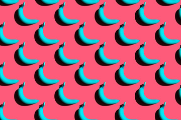 Blue bananas pattern on pink background. Creative funny food. Fresh season fruit texture with strong shadows