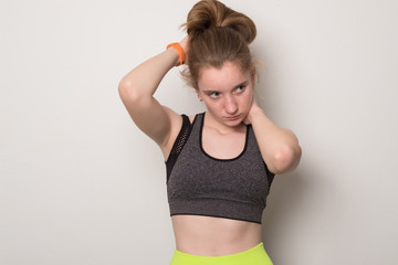Smiling young girl is engaged in fitness. Teen girl in sportswear. Sport girl in tank top for yoga.