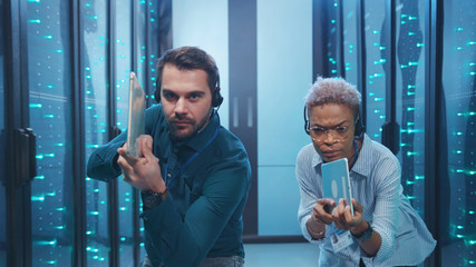 Funny-looking man and woman secret agents sneaking into database. Professional multi-ethnic spies...