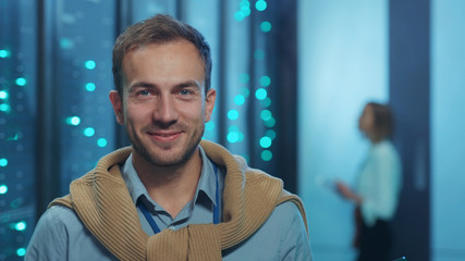 Portrait of handsome server specialist using laptop computer coworking in team at data center....