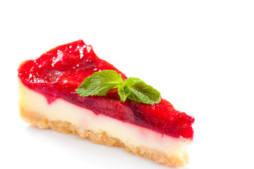 A piece of strawberry cake and a mint leaf, isolated on white