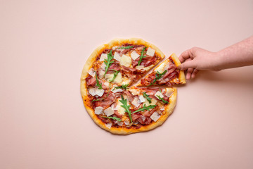 Pizza ham and cheese on pink background. Taking pizza slice