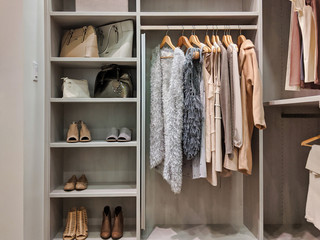 walk in closet with clothes hanging and shoes on shelving - obrazy, fototapety, plakaty