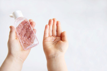 Children hands use a gel, disinfectant, antiseptic in a bubble, jar on a white background.