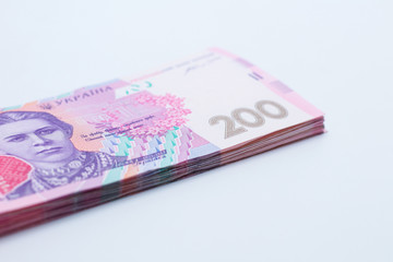 A lot of new banknotes in denominations of 200 Ukrainian hryvnias isolated on a white background with shadow. European money exchange. Ukraine currency. Selective focus