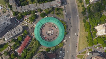interesting round shape of the building with a green roof, view from the drone, smooth cinematic movement of the drone