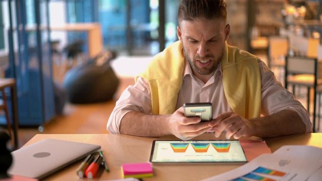 Caucasian man in smart casual clothing using cellphone gadget with high speed internet connection for checking web news about bitcoin crypto currency for making online investment via touch pad