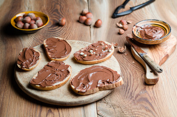 Sandwiches with chocolate cream on wood.