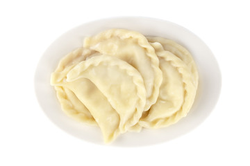 Plate with boiled varenyky, vareniki on white background
