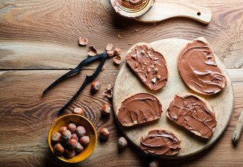 Sandwiches with chocolate cream on wood.