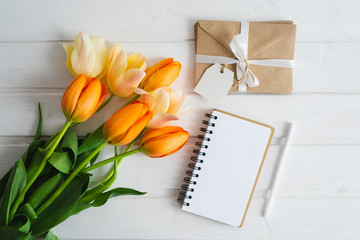 Notebook, pen, bouquet of tulips, envelopes. Flat lay.