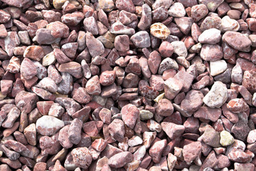 Red gravel, granite texture. Stone background. Fine pebbles. Construction material. The texture of the stones.