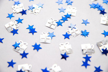 Blue sequins in the form of stars on a white background. New year's holiday and birthday. Background and texture.