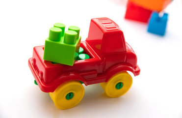 Children's construction kit with cubes and a red car on a white background. Children's entertainment. Development of hand motor skills. logic of thinking.