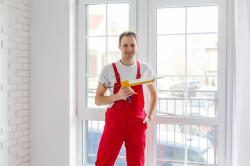 Worker in overalls setting up new windows in the office