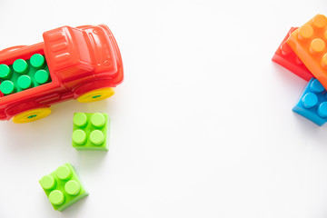 Obraz premium Children's construction kit with cubes and a red car on a white background. Children's entertainment. Development of hand motor skills. logic of thinking.