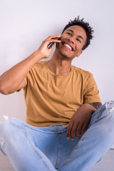 African american millennial man using technology. Young male texting with smart phone connected to internet isolated on white background with vertical copyspace. Technology musical concept indoors.