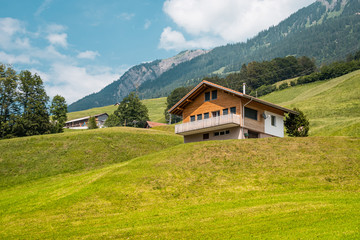 Fototapeta premium Summer view of traditional swiss house in Alps. Calm Small village in Switzerland