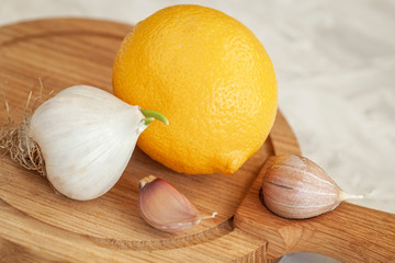Lemon and garlic on wooden cutting board close-up, flu and cold prevention, natural vitamins