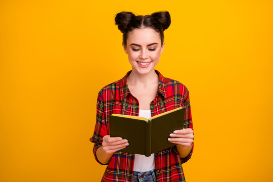 Photo of pretty student lady two cute buns hold book read interesting love story favorite novel addicted reader wear casual white red plaid shirt isolated yellow color background