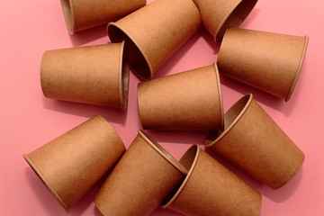 Craft paper cups for coffee or any drinks on a pink paper background. Concept of ziro waste, no plastic