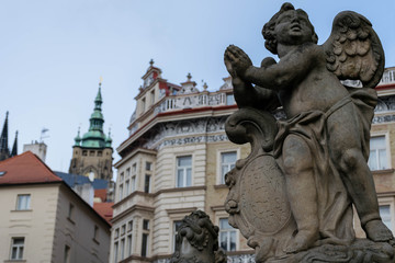 Obraz premium Angel sculpture and St Vitus Cathedral Tower on the background, Prague