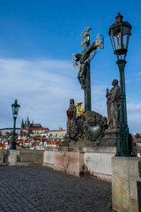 Fototapeta premium Statue of the Holy Crucifix and Calvary with St Vitus Cathedral on background, Prague