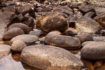 Fototapeta na wymiar Low closeup shot of river rock tranquil clear river bed calming background
