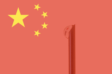 Chinese flag and vaccine needle from which a drop of liquid comes out. In the drop. there is a text that says covid-19. Concept of prevention and health care.