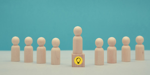 Creative idea, innovation. Think different. Person creation. Wooden figure stands on cube. Lightbulb sign, copy space