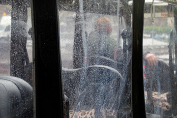 Man waiting in a plastic vehicle in a rainy day