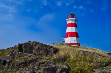 Fototapeta na wymiar Red and White Lighthouse on a Rocky Area near Digby Canada