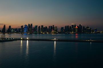 Fototapeta premium Panoramiczny nocny widok na drapacze chmur miasta Doha od strony morza