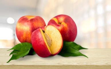Fresh ripe whole and cut tasty peach fruit on the desk