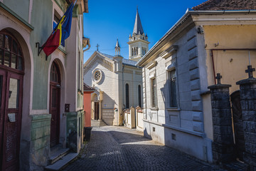 Street in historic part of Sighisoara city, Romania - view with Cathedral of Saint Joseph