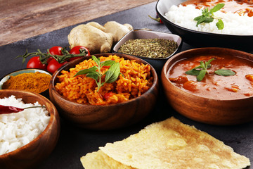 Chicken tikka masala spicy curry meat food in pot with rice and naan bread. indian food on table