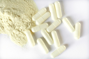 Fototapeta na wymiar white medical capsules and white powder next to a white background, isolate. antibiotics or drugs.