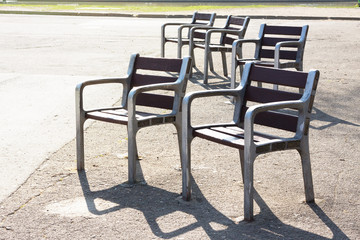 Fototapeta na wymiar Empty chairs in the morning sunlight. City Park. Barcelona, Spain.