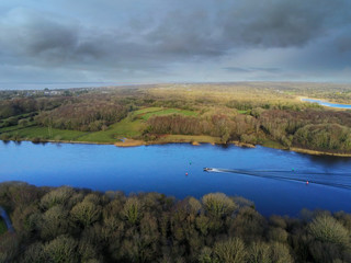 Aerial view on River Corrib, county Galway, Small fishing boat on water, blue cloudy sky. Warm sunny day.