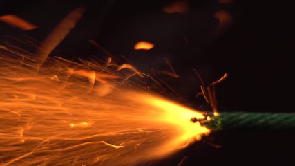 Close up macro shot of Burning fuse firecracker. Setting fire to wick of bomb