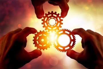 Hands holding three gear wheel