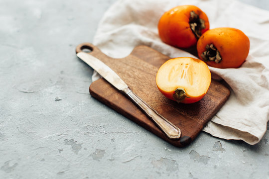 Fresh whole persimmon on wooden background