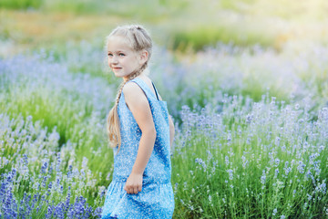 Little girl in lavender field. kids fantasy. Smiling girl sniffing flowers in summer purple lavender field.