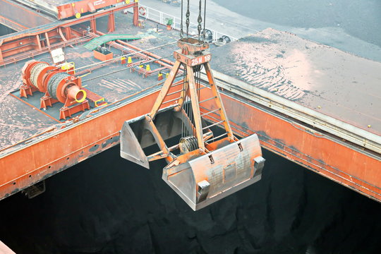 Cargo terminal for discharging coal cargos by shore cranes during foggy weather. Port Bayuquan,China. January, 2020.