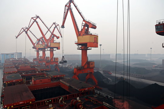 Cargo terminal for discharging coal cargos by shore cranes during foggy weather. Port Bayuquan,China. January, 2020. - Powered by Adobe
