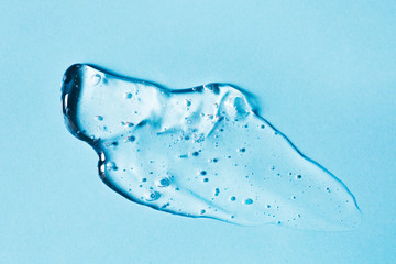 Smear of transparent gel on blue background.